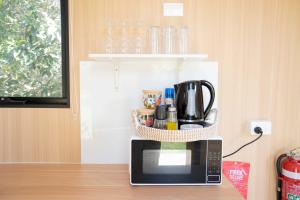a microwave with a basket on top of it at Bush by the Bay by Tiny Away in River Heads +21 photos