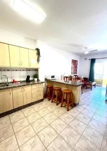 une grande cuisine avec un comptoir et des tabourets dans l'établissement El Oasis de Gara, à San Isidro