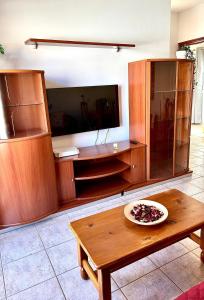 un salon avec une table et une télévision dans l'établissement El Oasis de Gara, à San Isidro