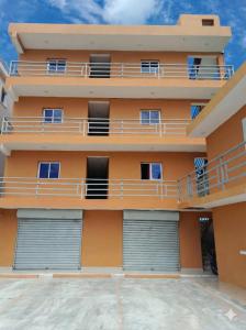 ein orangefarbenes Mehrfamilienhaus mit zwei Garagen in der Unterkunft Apartahotel ABC in Punta Cana