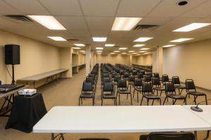 una habitación vacía con filas de sillas y mesas en Motel St-Eustache, en Saint-Eustache