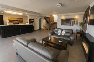 una sala de estar con un sofá y una mesa en Motel St-Eustache, en Saint-Eustache