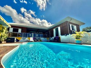 a swimming pool in front of a house at Villa Anj'any DESHAIES - 400 m à pied de la plage de Grande Anse in Deshaies