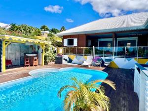 德赛Villa Anj'any DESHAIES - 400 m à pied de la plage de Grande Anse的一栋房子前面有游泳池