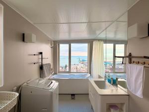 uma casa de banho com uma banheira, um lavatório e uma janela em 逸居&海音#200平方海景别墅#小樽步行街浪漫街附近#可以免费停放3台车#房间配有空调#暖气 em Otaru mais 37 fotografias