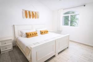 1 dormitorio blanco con 1 cama blanca grande y 2 almohadas en Boho Minimal 3-Min Beach Private Parking, en Puerto Aventuras