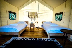 a room with two beds in a tent at Nawesa Resort in Eton