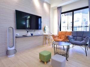 a living room with a couch and a tv at Summer Grass B&B 台東縣民宿1729號 in Taitung City