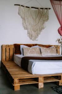 a bedroom with a wooden bed with white sheets and pillows at Scenic Mountain Cabin with Workspace - Close to Ella in Badulla +30 photos