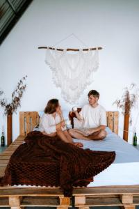 a man and a woman sitting on a bed at Scenic Mountain Cabin with Workspace - Close to Ella in Badulla