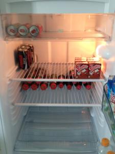 an open refrigerator filled with drinks and soda at Villa Verde Suites Sudoeste in Brasilia