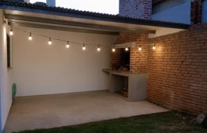 Chalet en Miramar, para 5 personas في ميرامار: فناء به أضواء وجدار من الطوب