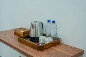 ein Tablett mit einer Kaffeemaschine und Wasserflaschen in der Unterkunft Vasachio Guest House in Uluwatu