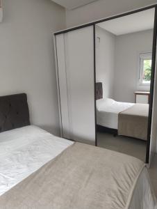 une chambre avec deux lits et un miroir dans l'établissement Casa para Veraneio em Torres, à Torres 16 autres photos