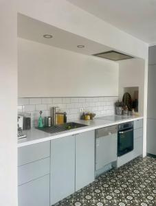 a kitchen with white cabinets and a counter top at Suite de 35 m2 in Les Lilas
