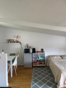 a bedroom with a bed and a table with a microwave at Suite de 35 m2 in Les Lilas