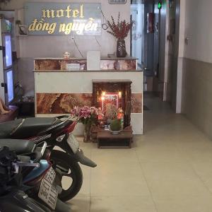 Una motocicleta estacionada frente a una chimenea en una tienda. en Đồng Nguyễn Hotel, en Tân Ðiền
