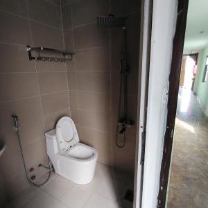Un pequeño baño con inodoro y ducha. en Đồng Nguyễn Hotel, en Tân Ðiền 3 fotos más