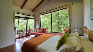 a bedroom with a bed and a large window at Monteverde Casa Mia, near main attractions and town! in Monteverde Costa Rica