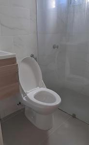 ein weißes Badezimmer mit Toilette und Dusche in der Unterkunft Apartahotel ABC in Punta Cana