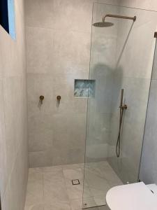 une salle de bain avec une douche avec une porte vitrée dans l'établissement Perch Lorne, à Lorne 7 autres photos