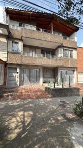 ein großes Backsteingebäude mit einem Parkplatz davor in der Unterkunft accommodation in medellin, laureles, belen rosales CASA GAMA MEDELLIN in Medellín