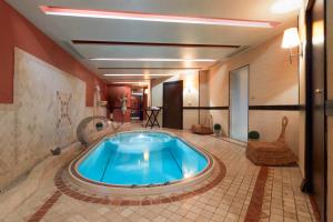 a large blue tub in a room with a tiled floor at Hôtel Europe and Spa in Reims