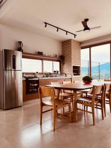 a kitchen with a table and chairs and a refrigerator at Casa Vista Serrana in São Pedro