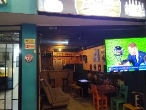 a restaurant with a bar with a large screen television at Kumho in Medellín
