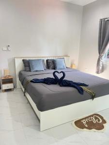 a bedroom with a bed with a blue ribbon on it at Samakki Residence - Modern Rooms, Quiet Area, Near the Beach in Rawai Beach