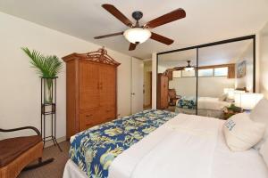 卡哈纳Kahana Reef 117 · KR 117 Renovated OceanFront 1BD w Ocean Views的一间卧室，里面有一张床和一个吊扇 更多41张照片