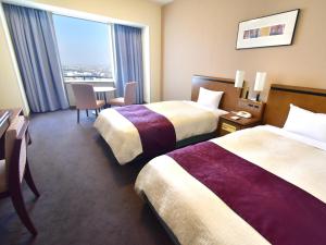 a hotel room with two beds and a table at Star Gate Hotel Kansai Airport in Izumi-Sano