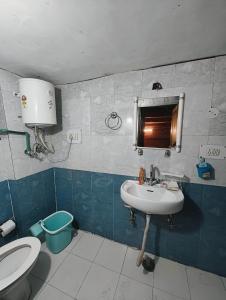 a bathroom with a sink and a toilet and a mirror at Oran Stays Shoja in Shoja