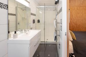 a white bathroom with a sink and a shower at Queenstown Top 10 Holiday Park in Queenstown +80 photos