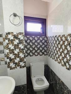 a bathroom with a toilet and a window at Oran Stays Shoja in Shoja +50 photos
