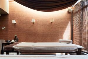 Ce lit se trouve dans une chambre dotée d'un mur en briques. dans l'établissement Hôtel Europe and Spa, à Reims