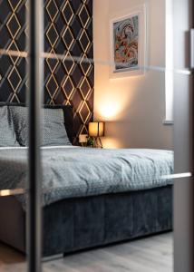 a bedroom with a bed with a black headboard at LuxCity Apartment in the Center of Nowy Targ, FREE PARKING in Nowy Targ