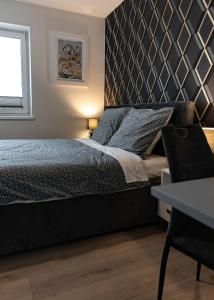 a bedroom with a bed with a black headboard at LuxCity Apartment in the Center of Nowy Targ, FREE PARKING in Nowy Targ