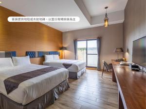a hotel room with two beds and a flat screen tv at Hualien Toongmao Resort in Jian