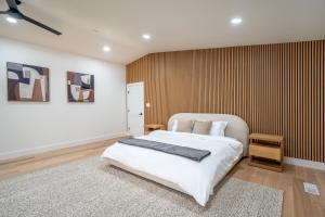a bedroom with a white bed and a striped wall at Modern Entire Home Near UVA in Charlottesville
