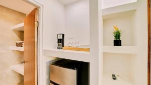 una piccola cucina con ripiani bianchi e lavandino di Gaviota Suite 3 a Puerto Viejo