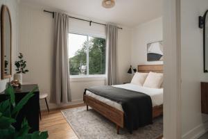 圣阿加瑟莫Luxury Lakefront Retreat Spa Beach Ski的一间卧室，里面有一张床和一扇窗户。