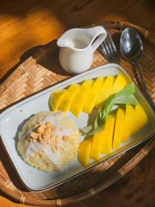 a plate of food with fruit and a cup of coffee at Comfy room - InnerZen Mekong Riverside homestay Ben Tre in Ben Tre
