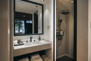 een badkamer met een wastafel en een douche bij Dongsheng Design Hotel in Dali in Dali +58 foto's