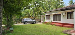 阿努拉德普勒Nature's Touch Villa的停在房子前面的汽车