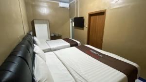 ein Hotelzimmer mit zwei Betten und einem Fernseher in der Unterkunft Solaris Malioboro in Jetis