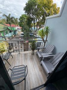 Un balcón con sillas y árboles y una calle. en Goldland Caelestis Guest House, en Bacolod