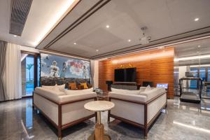a living room with two couches and a television at Sanya Haitang Bay Renguan Sea View Pool Villa (Water World Duty Free City Store) in Sanya