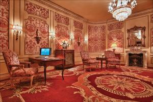 a room with a desk and chairs and a chandelier at The Westgate Hotel in San Diego