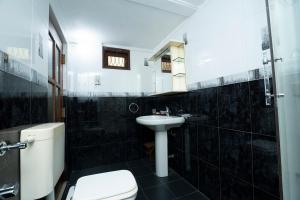 a black tiled bathroom with a toilet and a sink at Brescia villa - Your Private Escape in matara in Gandara West +41 photos